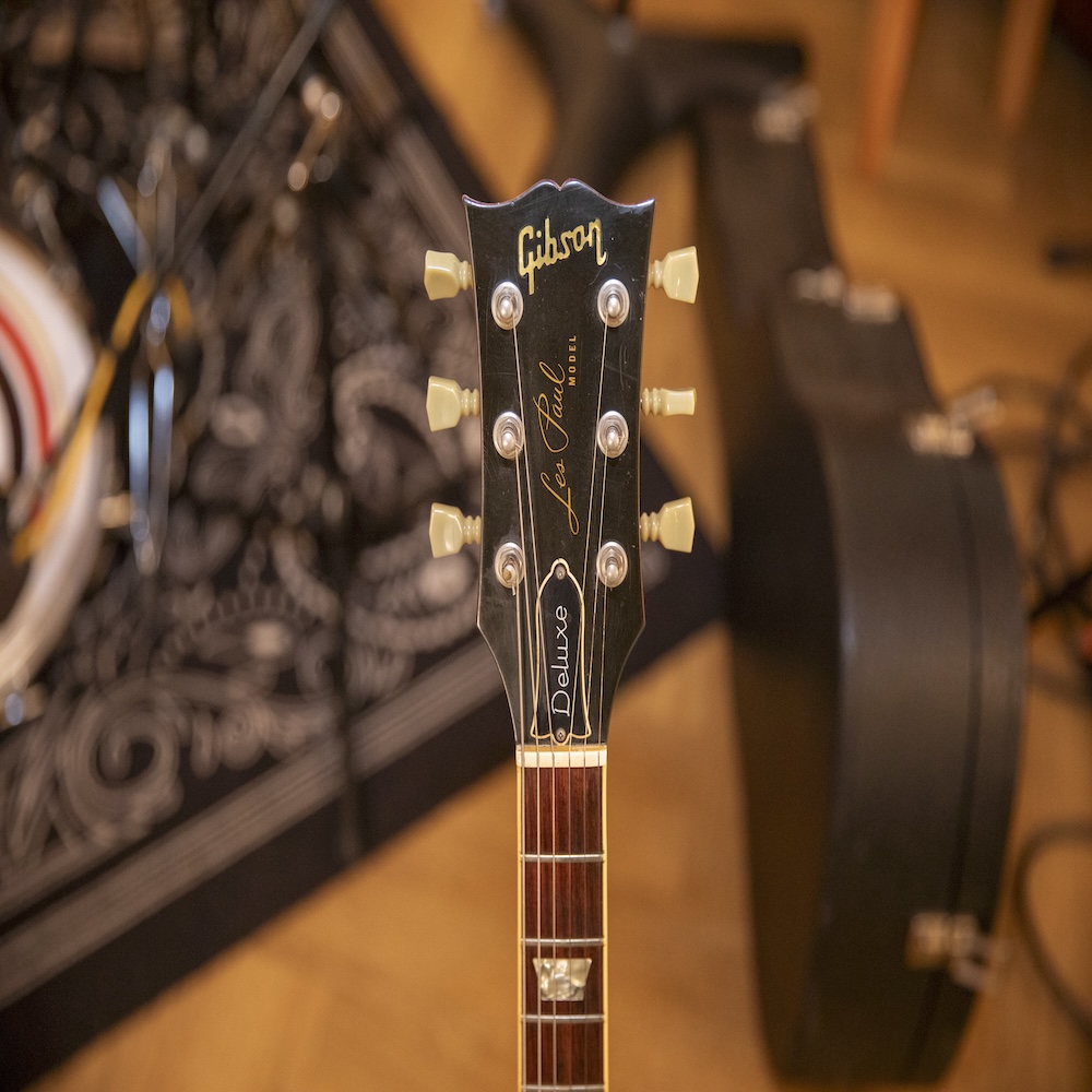 The neck of a Gibson guitar in centre focus